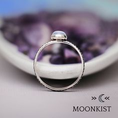 This beautiful Sterling Silver Oval Blue Chalcedony Cabochon Ring with Patterned Band features an 8 x 6 mm oval cabochon gemstone of your choice. The stone is securely set in a bezel mounting. This band has a unique Infinite Knot motif and the interior of this band has been gently curved and rounded for ease of wear. Fine Silver Bezel, Sterling Silver Pattern Wire, 8x6 mm Oval Cabochon Dimensions - Band width - 3 mm (about .11 inches), Stone - 8x6 mm, Stone Height - 5 mm Includes free resizing a Adjustable Oval Birthstone Ring With Bezel Setting, Anniversary Moonstone Ring With Oval Cabochon, Oval Cabochon Birthstone Promise Ring, Dainty Oval Cabochon Ring, Oval Moonstone Stackable Rings As Gift, Oval Pearl Gemstone Promise Ring, Moonstone Stackable Rings For Gift, Oval Stackable Moonstone Ring For Anniversary, Oval Moonstone Birthstone Ring Gift