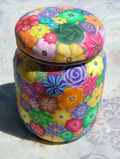 a multicolored box with flowers painted on the lid and bottom, sitting on a white surface