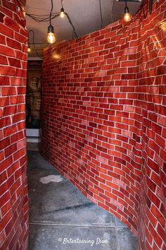 a red brick wall with lights hanging from it