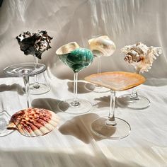 four wine glasses with seashells in them