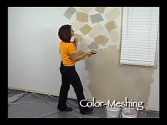 a woman is painting the walls in an empty room