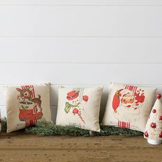 five christmas pillows lined up on a table