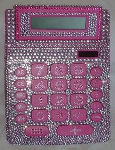 a pink and silver calculator sitting on top of a white countertop with lots of diamonds