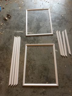 three frames sitting on top of a floor next to each other in front of a blue object