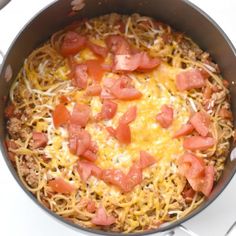 a skillet filled with spaghetti and tomatoes