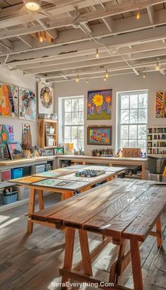 a room filled with lots of wooden tables and paintings on the wall above them,