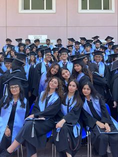 a group of people in graduation gowns posing for a photo