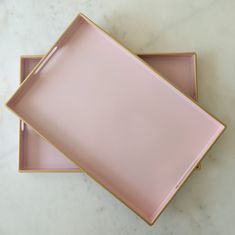 two pink trays sitting on top of a marble counter