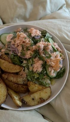 a white plate topped with potato wedges and salad