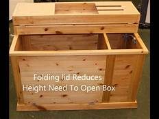 a large wooden box sitting on top of a floor next to another box with the words folding lid reduces height need to open box