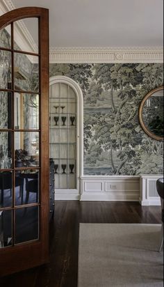 a living room with a large mirror on the wall next to a table and chairs