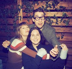 two women and a man are posing for a photo with their arms around each other