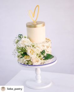 a wedding cake with white flowers and gold decoration