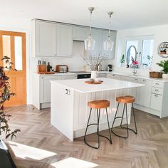 a kitchen with two stools and a center island in the middle of the room