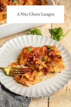 a white plate topped with lasagna next to a fork