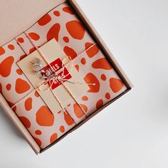 an orange and white gift box with red hearts on it