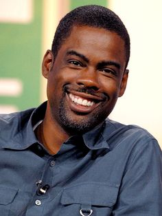 a smiling man in a blue shirt is looking at the camera