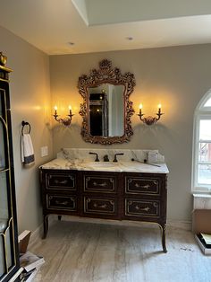 a bathroom with a large mirror and double sink vanity in it's center area