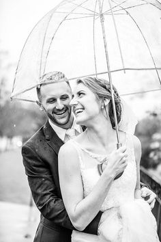 a bride and groom standing under an umbrella