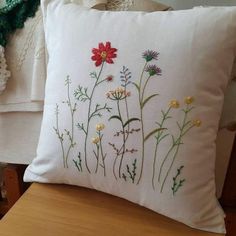 a white pillow with flowers embroidered on it