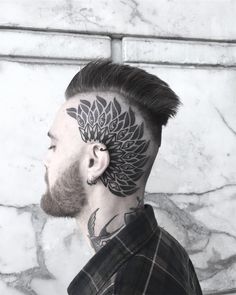 a man with a flower tattoo on his head and undercuts behind his ear