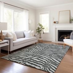 a living room filled with furniture and a fire place in front of a window on top of a hard wood floor