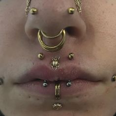 a woman with gold nose piercings on her lips and tongue ring in front of her mouth