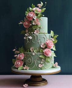 a three - tiered cake with pink flowers on the top and green icing