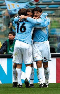 two soccer players hugging each other on the field