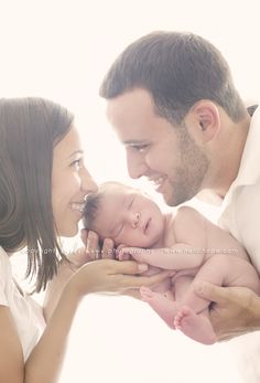 a man and woman holding a baby in their hands with the caption g above them