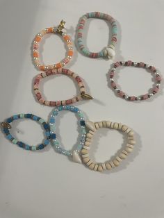 This is our beach bracelet collection! We have many different beach themed bracelets. They are all made with stretchy clear elastic string. White Adjustable Stretch Bracelet With Beachy Style, Adjustable White Stretch Bracelet With Beachy Style, White Adjustable Beachy Stretch Bracelet, White Strand Stretch Bracelet For The Beach, Beachy White Stretch Bracelet For Vacation, White Beachy Stretch Bracelet For Summer, Multicolor Stackable Stretch Bracelet For Beach, Trendy Stackable Beaded Bracelets For Beach, White Stackable Beaded Bracelets For Beach