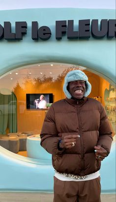 a man standing in front of a blue and white sign with the words golf le fleur written on it