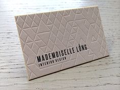 a close up of a business card on a wooden table with the name mademoise long