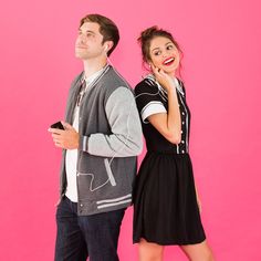 a man and woman standing next to each other in front of a pink background with headphones on