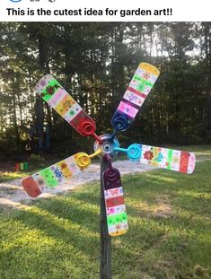 a colorful wind spin sitting on top of a lush green field