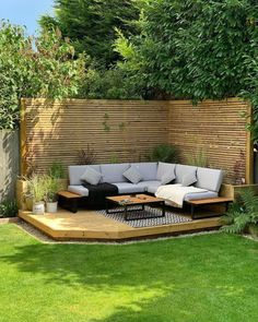 a couch sitting on top of a wooden platform in the middle of a grass covered yard