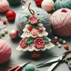 crocheted christmas tree ornament surrounded by balls of yarn and knitting needles