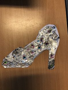 a pair of shoes that are sitting on top of a wooden table, covered in silver and multicolored jewels