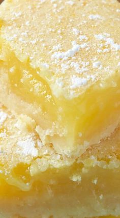 two pieces of lemon bars stacked on top of each other with powdered sugar on them