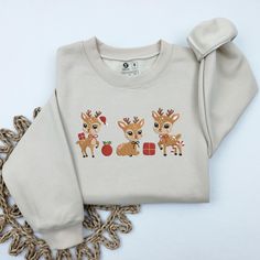 EMBROIDERED Christmas Reindeer Sweatshirt, Reindeer Shirt, Christmas Crewneck, Holiday Sweater, Christmas gifts for women, Unisex Sweatshirt Product Details: * T-Shirts: Made from 100% premium cotton, our T-shirts are soft, comfortable, and durable. * Sweatshirts: Crafted from a blend of 50% cotton and 50% polyester, our sweatshirts offer both warmth and breathability. Why Choose Us? * Fast Production and Shipping: We take pride in our quick turnaround times. Production takes just 3-7 days, and shipping typically takes 5-7 days on average. How to Order: 1) Select Your Style & Color 2) Personalize Your Design: Let us know any specific details or requests to make your order unique. 3) Add to card and Check Out. Why Our Customers Love Us: * High-Quality Materials: We use only the best fabrics Reindeer Sweatshirt, Cow Sweater, Farm Christmas, Reindeer Shirt, Holiday Clothing, Holiday Outfits Women, Christmas Cow, Santa Sweatshirt, Retro Santa