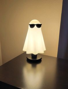 a lamp with shades on it sitting on a black table next to a white wall