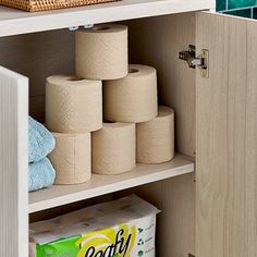 several rolls of toilet paper sitting on top of a wooden shelf next to a basket