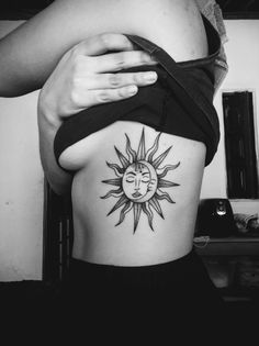 a woman with a sun tattoo on her stomach