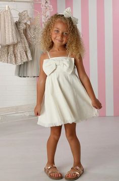 Introducing the girls' white front bow Remi dress by the renowned designer brand, OohLaLa Couture – a delightful and fashionable choice for your little one! This dress is designed to make your little girl feel like a true fashionista. The classic white color is perfect for any occasion. It's available in sizes 12M-14, ensuring a comfortable and stylish fit for a range of ages. The standout feature of this dress is the front bow adorning the chest. It adds a touch of chic and sophistication that's perfect for special occasions or even just a fun day out. The bow is a delightful detail that elevates the dress and showcases your child's unique style. Crafted with care and attention to detail, the Remi Dress is not only stylish but also comfortable for your little one to wear. It allows for ea Cute Cotton Dress With Bow Tie Back, Chic White Dress For Dress-up, White Chic Dress For Formal Occasions, Playful White Dress With Bow, Spring Dress With Bow Tie Back For Dress-up, White Bow Tie Back Dress For Spring, White Spring Dress With Bow Tie Back, White Dress With Bow Tie Back For Spring, White Spring Dresses With Bow Straps