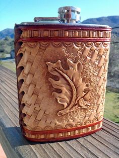 a brown flask is sitting on a wooden bench