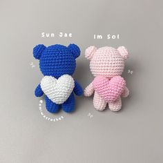 two small crocheted teddy bears sitting next to each other on a gray surface