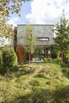 the house is surrounded by tall grass and trees, with an open area for sitting