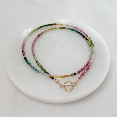 This dainty and charming Tiny Rainbow Tourmaline Minimalist Beads Necklace is the perfect accessory for your everyday look. Featuring small semi-precious gemstone beads in a beautiful spectrum of colors, this boho choker is delicately handcrafted with a 14k gold filled front clasp for a touch of elegance. Elevate your style with this unique and trendy beaded jewelry piece that will surely make a statement wherever you go. * 2.5mm - 3mm semi precious stone gemstones                      * Waterme Multicolor Tiny Beads 14k Gold Filled Jewelry, Dainty 14k Gold-filled Beaded Necklaces, 14k Gold-filled Jewelry With Tiny Beads, Everyday 14k Gold-filled Necklace With Tiny Beads, Delicate 14k Gold-filled Necklace With Tiny Beads, Boho Choker, Tourmaline Beads, Pearl Gemstone, Necklace Sizes