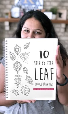 a woman holding up a book with the title 10 step by step leaf doodle drawings