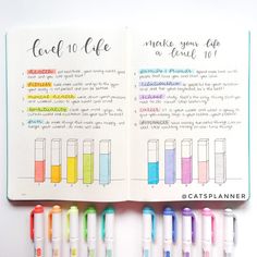 an open notebook with markers and pens on it, next to the pages are colored in different colors